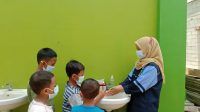 Fikri Laili Zakiyaturrohmah mengajari anak-anak cara mencuci tangan yang benar (25/10)